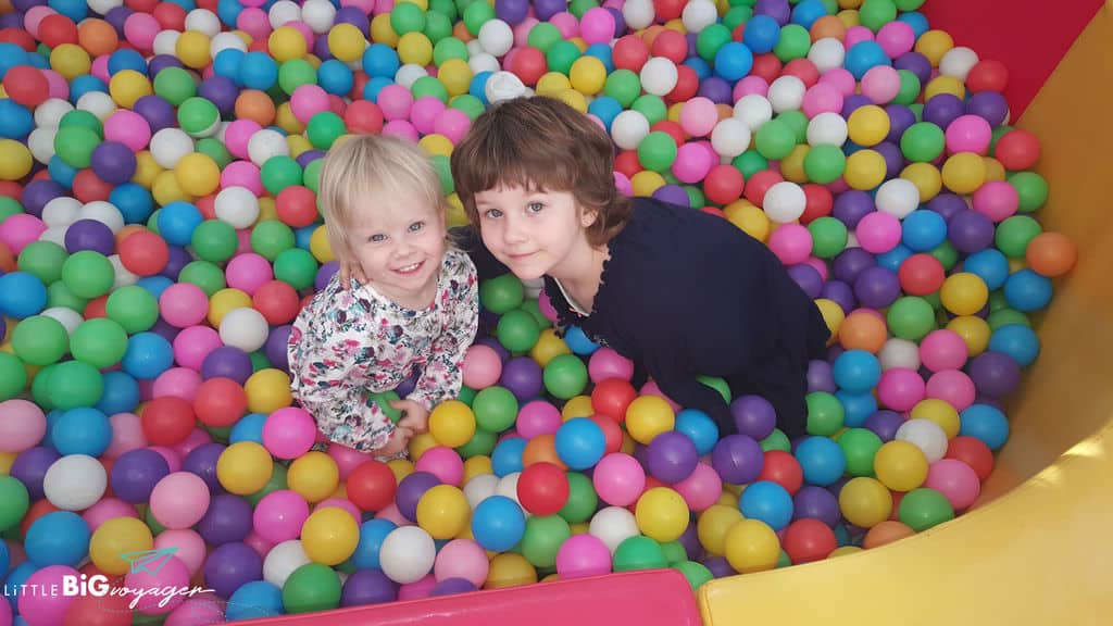 little J and big J in a ball bath at a play cafe in Providencia